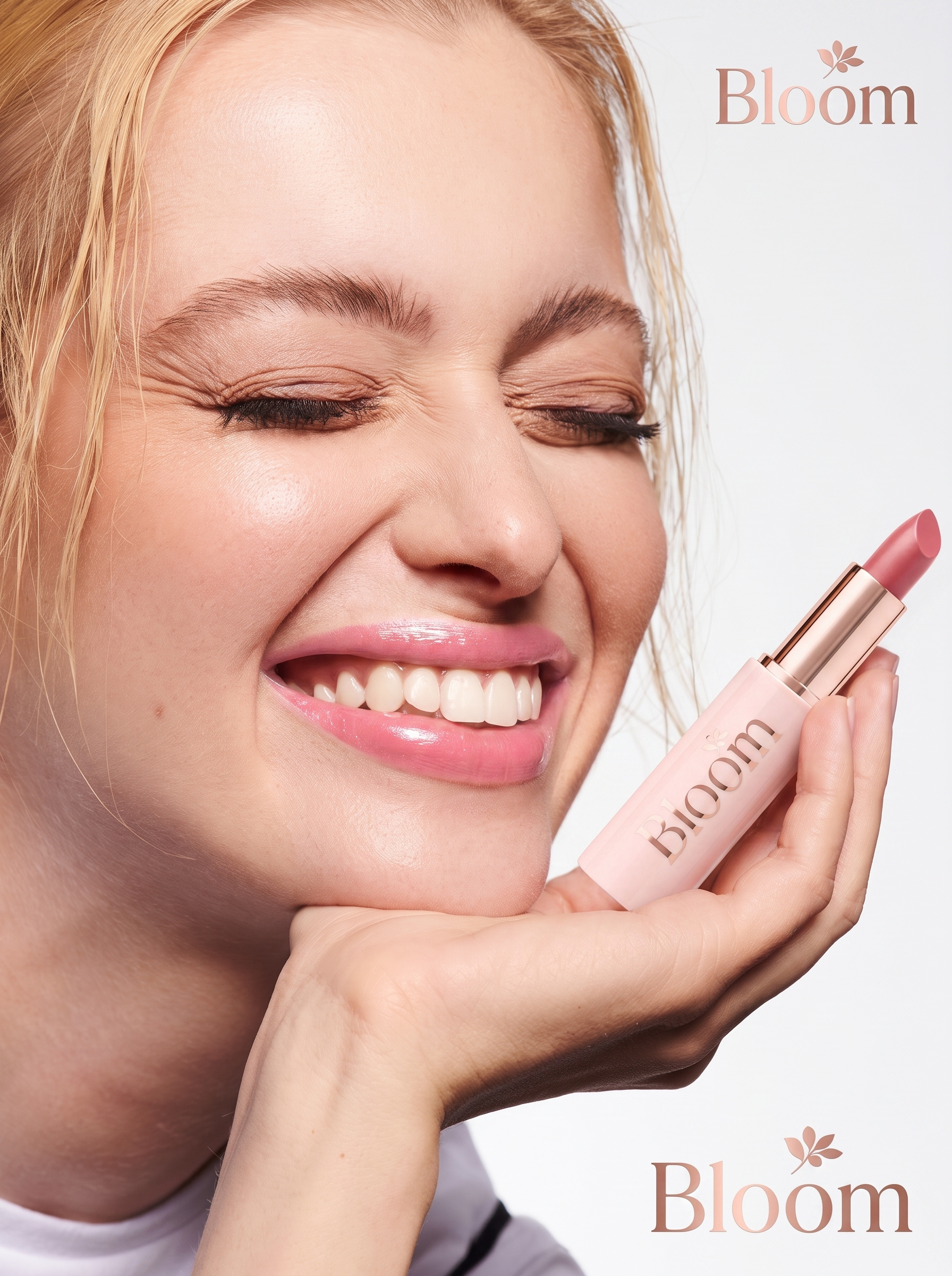 Beauty portrait: smiling model resting her chin on a hand that holds a pale pink lipstick